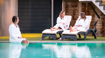 Vrouwen die genieten bij het zwembad van Fletcher Wellness-Hotel Brabant-Mill